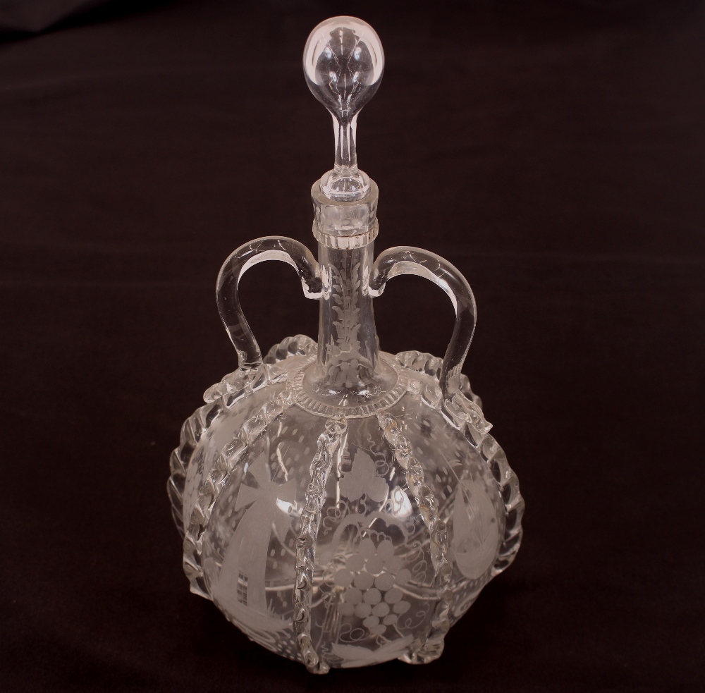 An antique Dutch decanter, with loop twin handles, etched decoration of vine leaves, ships and