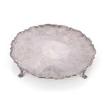 A silver plated salver with pie crust border raised on four hoof feet, retailed by Finnigans of