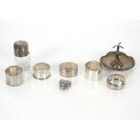 Five various silver napkin rings; a silver topped toilet jar; and a silver ring stand (7)
