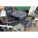 A circular topped garden table and four matching c