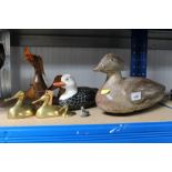 A wooden decoy duck and various duck ornaments
