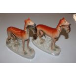 Two standing antique Staffordshire greyhounds with