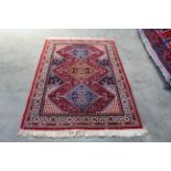 An approx. 6'6" x 4'2" red patterned rug