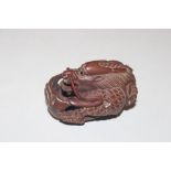 A carved wooden Netsuke in the form of a dragon