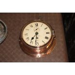 A copper and brass cased ships bulkhead type clock