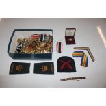 A box containing various button, badges, coins etc