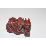 A carved wooden Netsuke in the form of a dragon