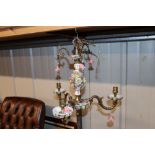 A floral encrusted decorative three light chandeli