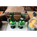 A pair of green glass and floral decorated decante