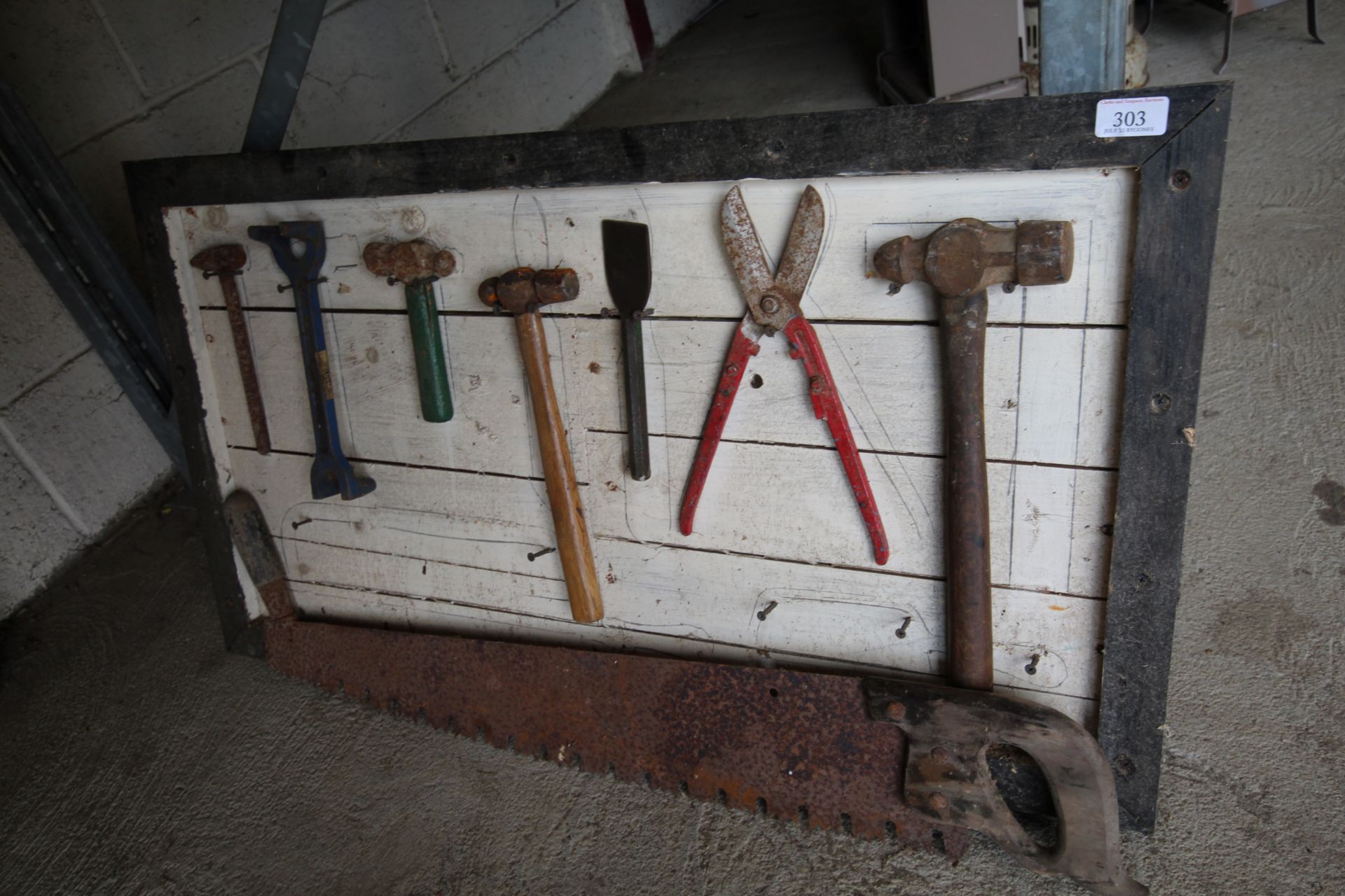 Seven vintage tools mounted on a display board and