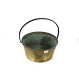 A large antique brass jam pan with metal loop hand