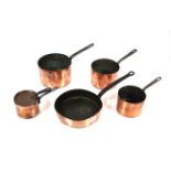 Five antique copper graduated saucepans with iron