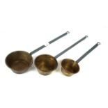 Three brass graduated ladles with painted iron han