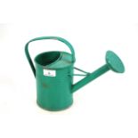 A small green painted vintage watering can with ro