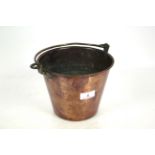 A copper pail with brass swing handle