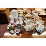 A collection of various miniature china tea pots e