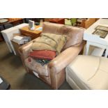 A brown leather upholstered armchair