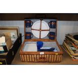 A wicker picnic hamper and contents