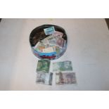 A tin of various coinage and banknotes