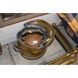 An antique copper kettle and a brass coal scuttle