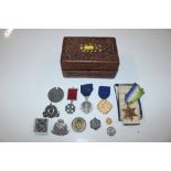 A wooden trinket box containing medals, badges etc