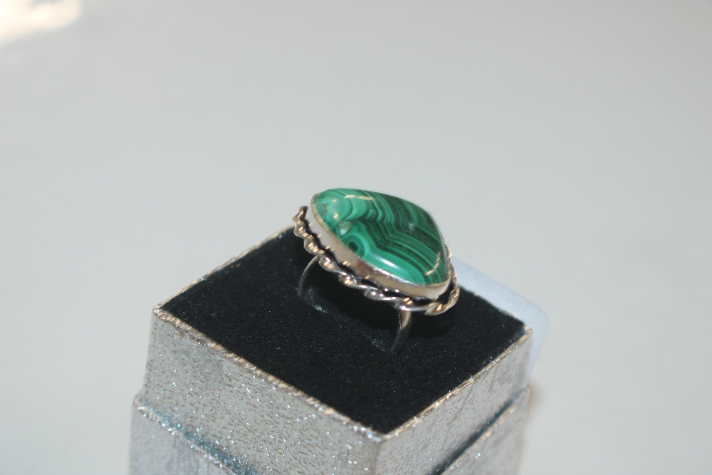 A white metal ring set with malachite