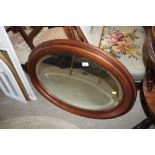 An oval mahogany framed bevelled edge wall mirror