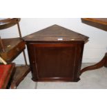 A small mahogany hanging corner cupboard