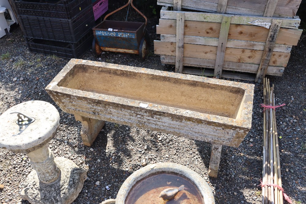 A concrete garden planter raised on concrete stand