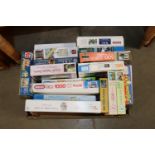 A box of various jigsaw puzzles
