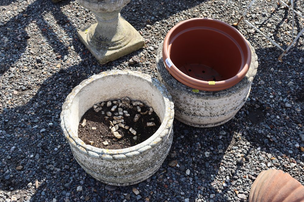 Two concrete garden planters and two plastic plant