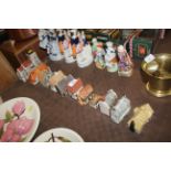 A collection of various pottery model cottages to