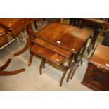 A nest of three mahogany scissor occasional tables