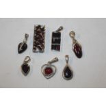 Seven Sterling silver and garnet set pendants, app