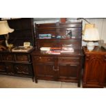 An Ercol dresser raised on cupboard base fitted tw