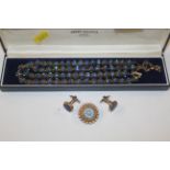 A box containing beaded necklace, brooch and cuff-