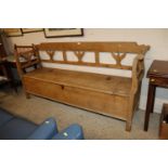 A large stripped pine settle with lift-up storage