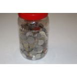 A plastic jar of various coinage