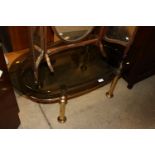 A brass and smoked glass oval coffee table