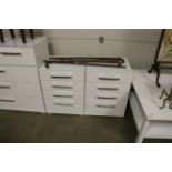 A pair of modern white four drawer bedside chests