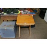 A wooden child's school desk with flip top lid on