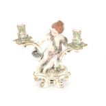 A late 19th Century continental porcelain Meissen type two branch candelabra, supported by a