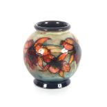 A Moorcroft baluster vase, having raised flower head decoration, green signature to base, stamped "