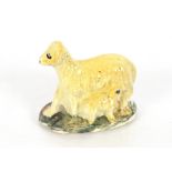 An early 19th Century Prattware figure of a dog and her puppy, 7.5cm long