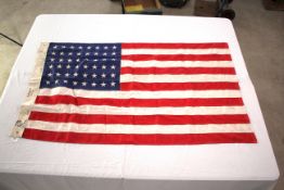 A Stars & Stripes flag marked U.S.M.C. 1943, appro