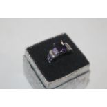 A purple and white stone set dress ring