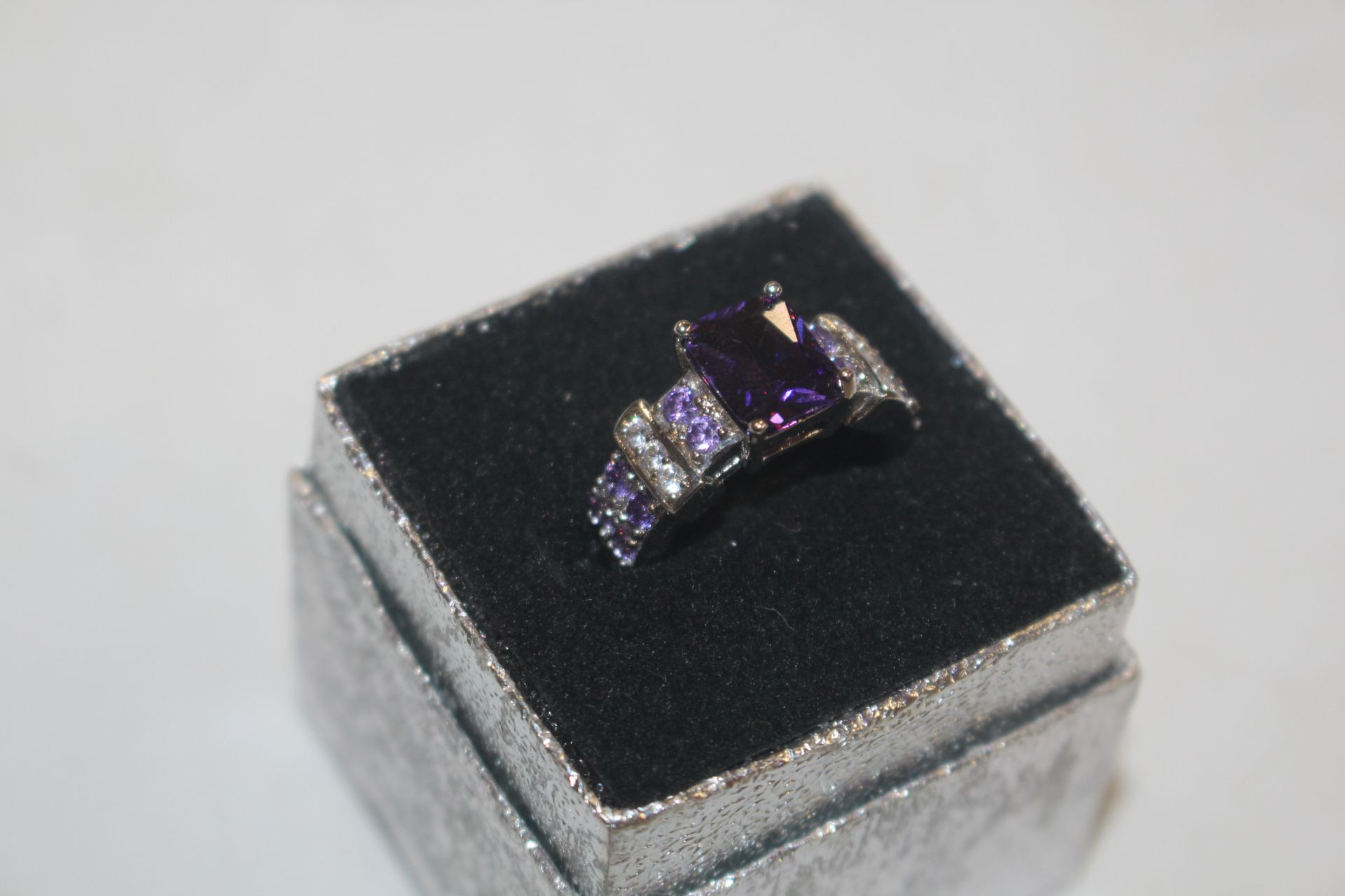 A purple and white stone set dress ring