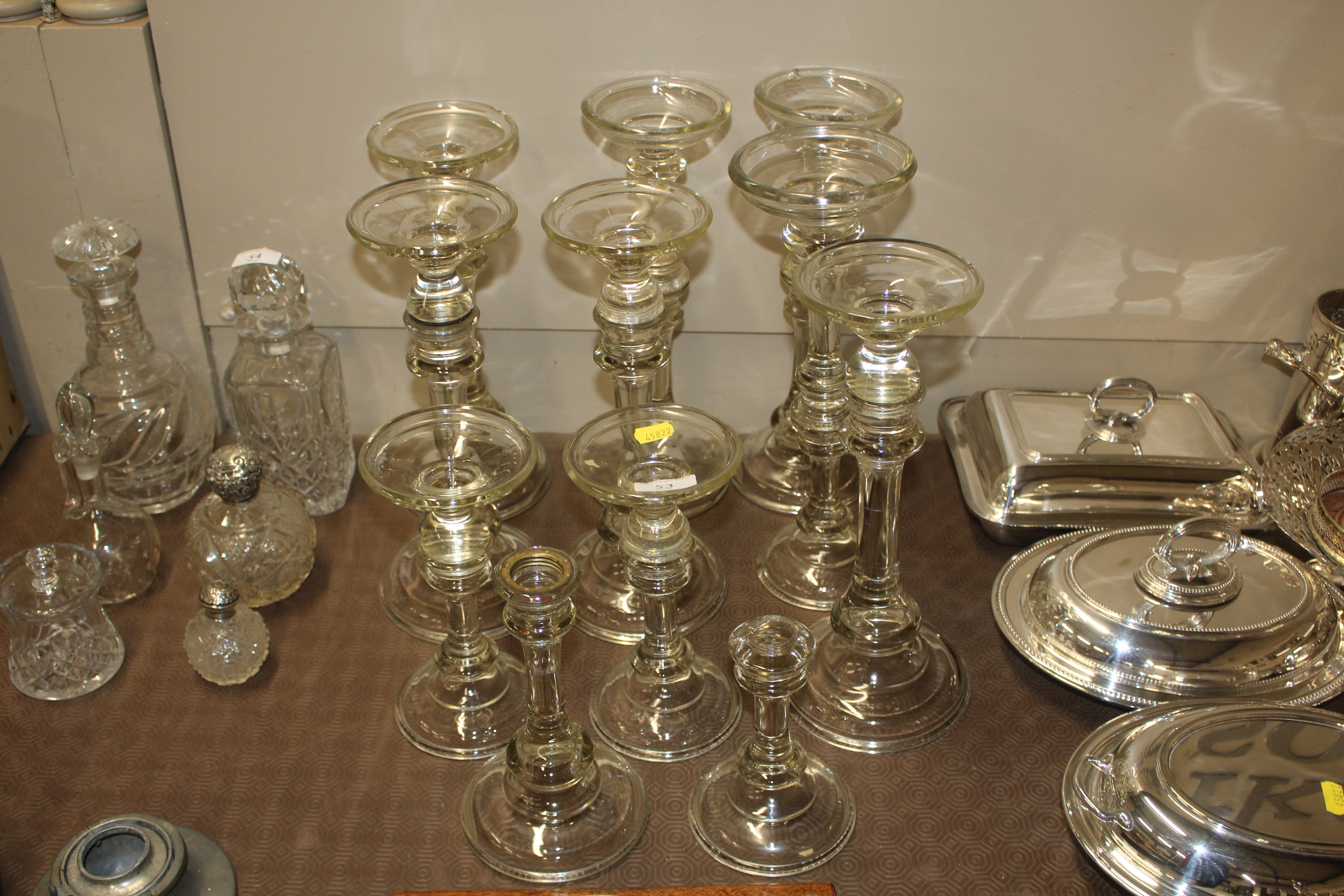 A quantity of glass candlesticks AF