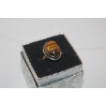 A white metal and tigers eye set ring