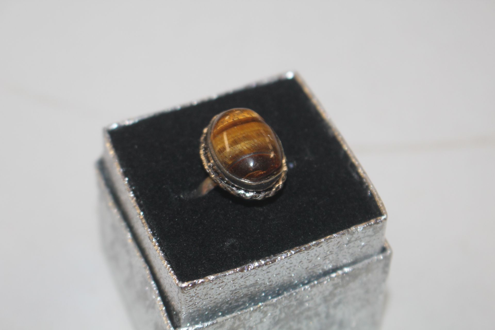A white metal and tigers eye set ring